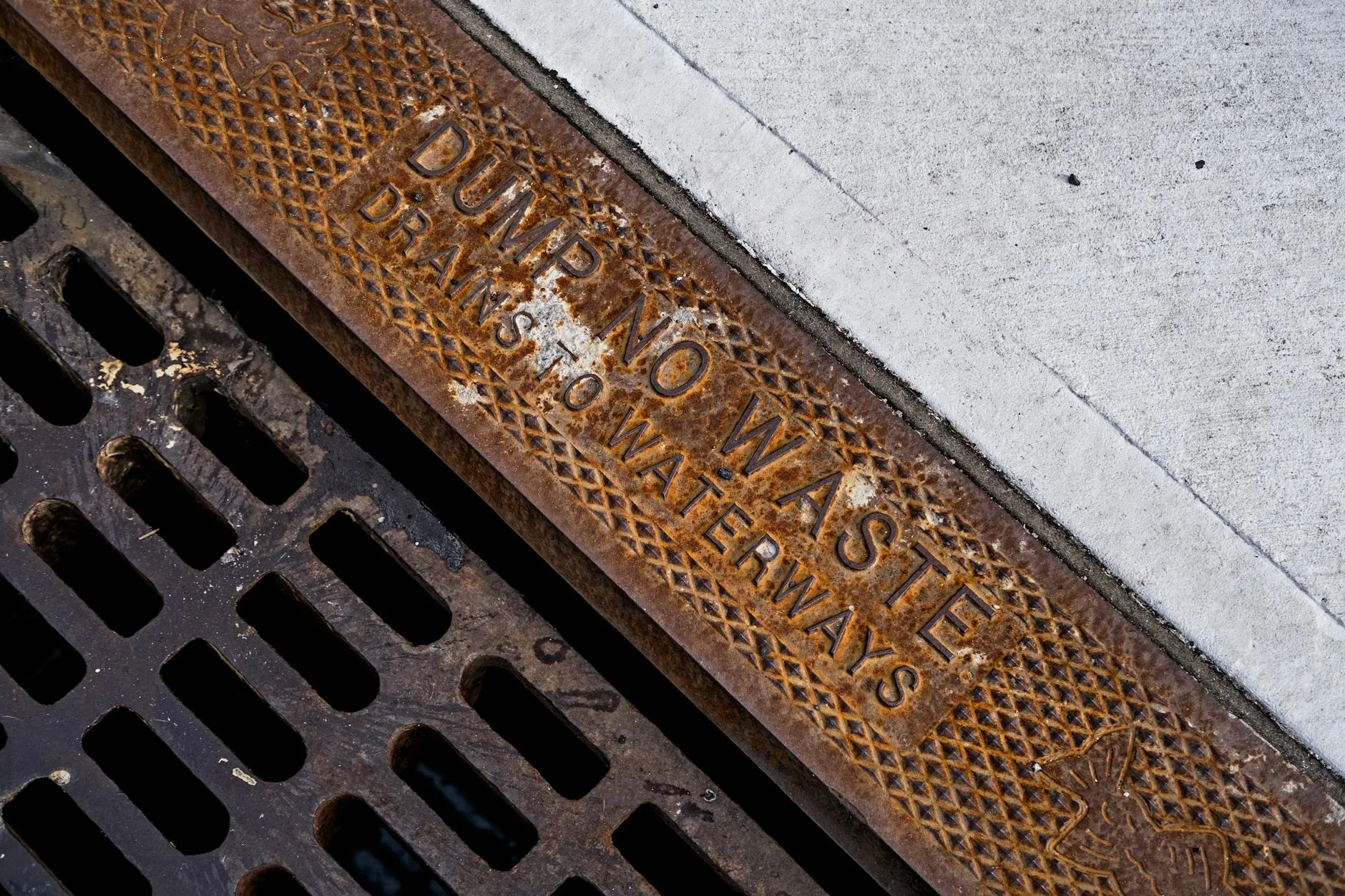 Linear drainage channel with grate set into patio paving