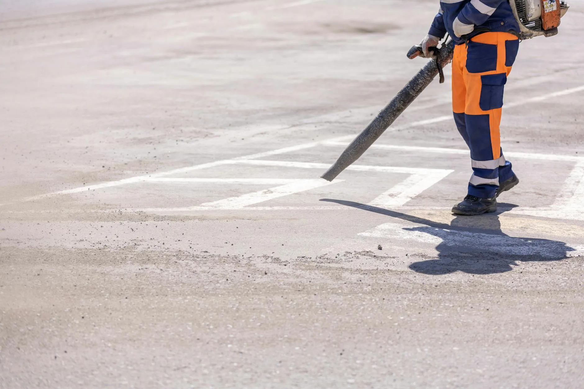 Person using a garden blower to clean outdoor surfaces