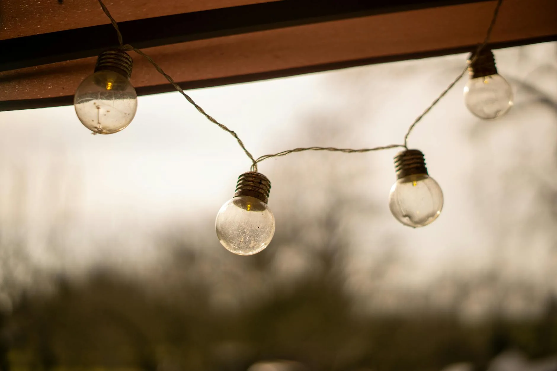 Warm white string lights creating atmosphere on garden patio at twilight
