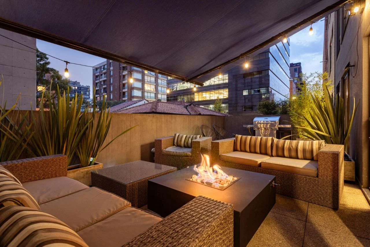 Covered outdoor terrace in the evening with fire feature and patio heater — ideal placement