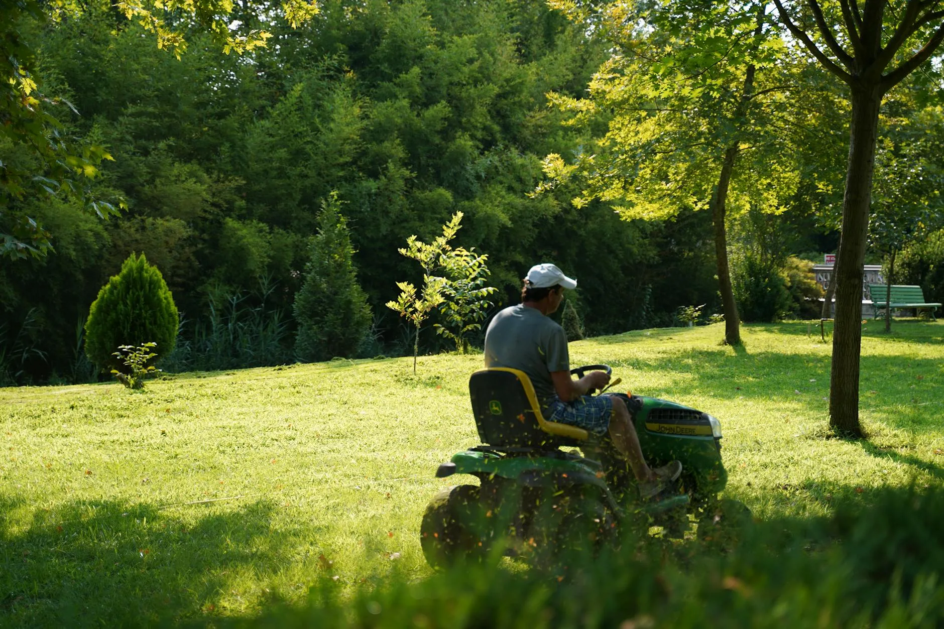 Person mowing a lawn in a garden on a summer day