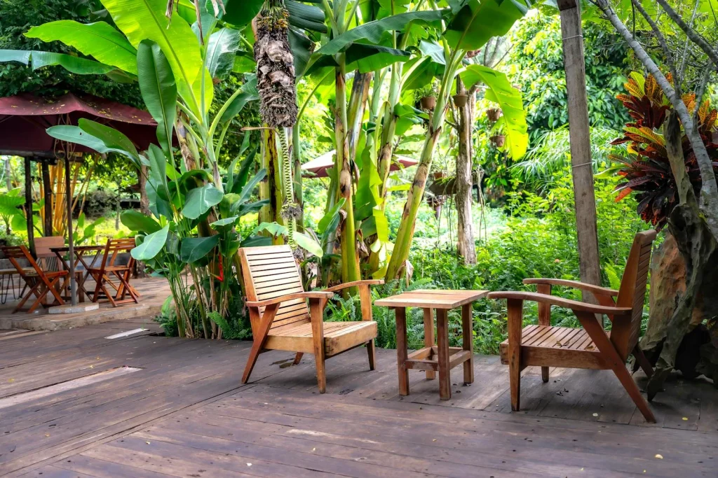 Teak garden chairs and table on a weathered wooden patio deck