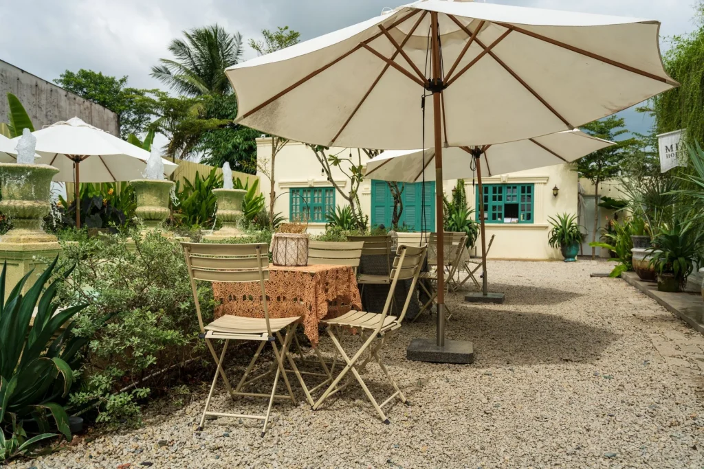Cantilever garden parasol shading patio furniture in a garden