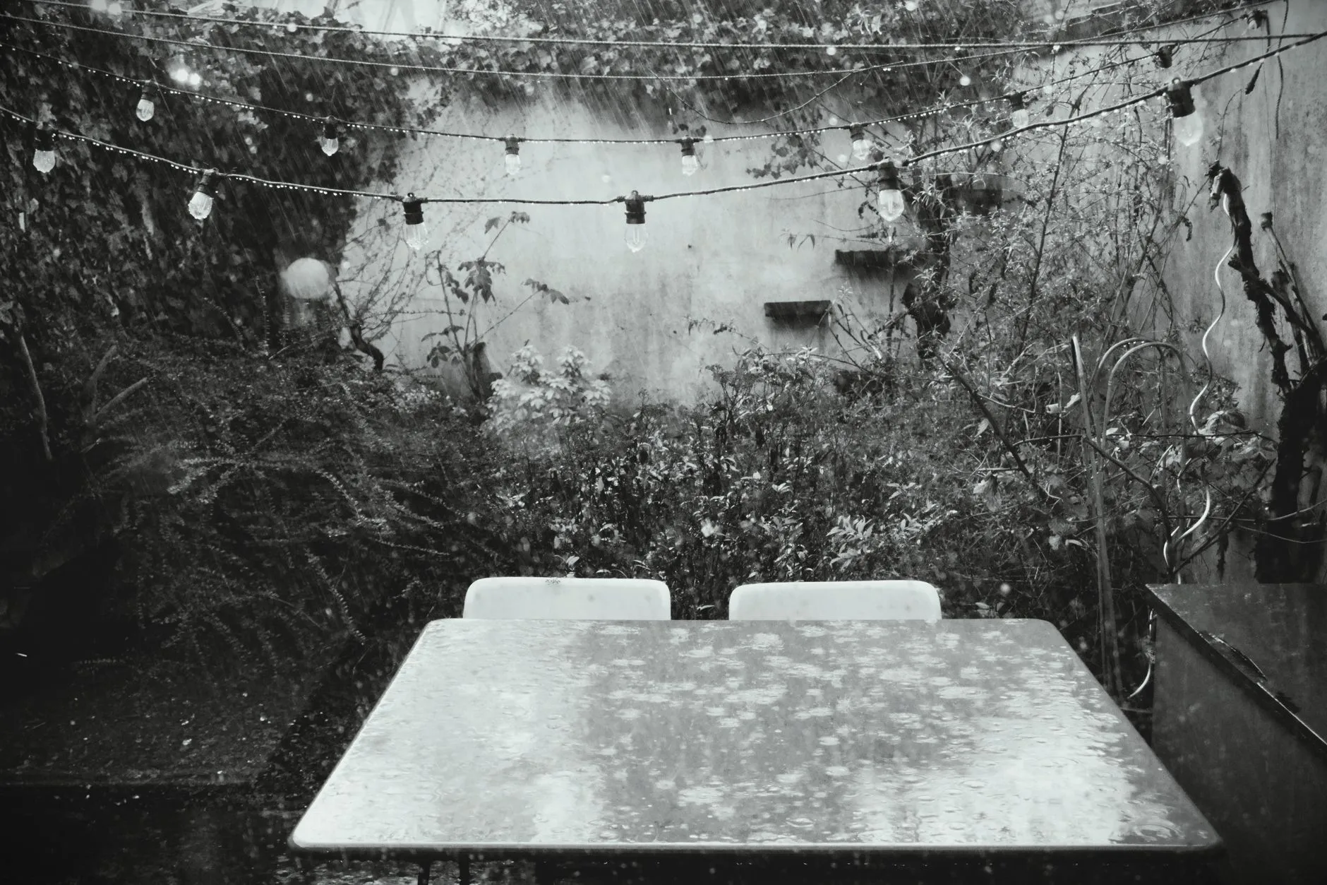 Garden furniture cover protecting a patio set from rain