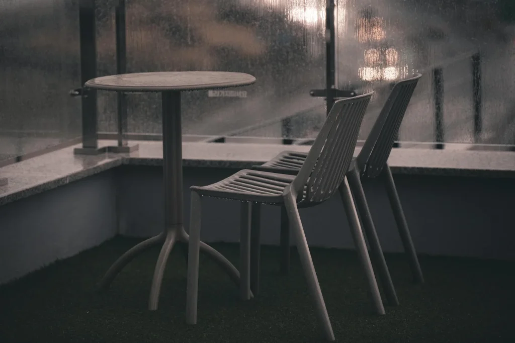 Covered garden furniture set protected on a wet patio
