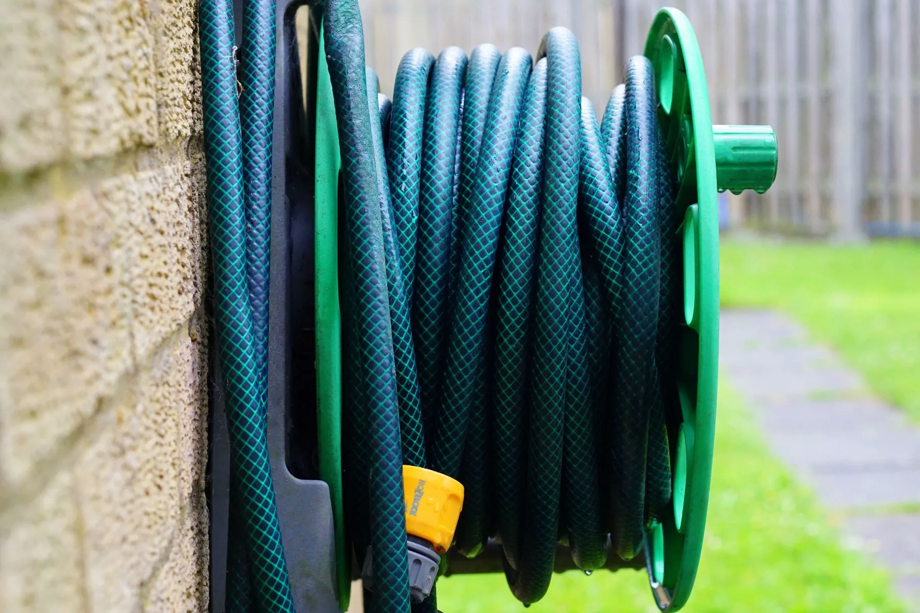 Coiled reinforced garden hose stored on a wall reel