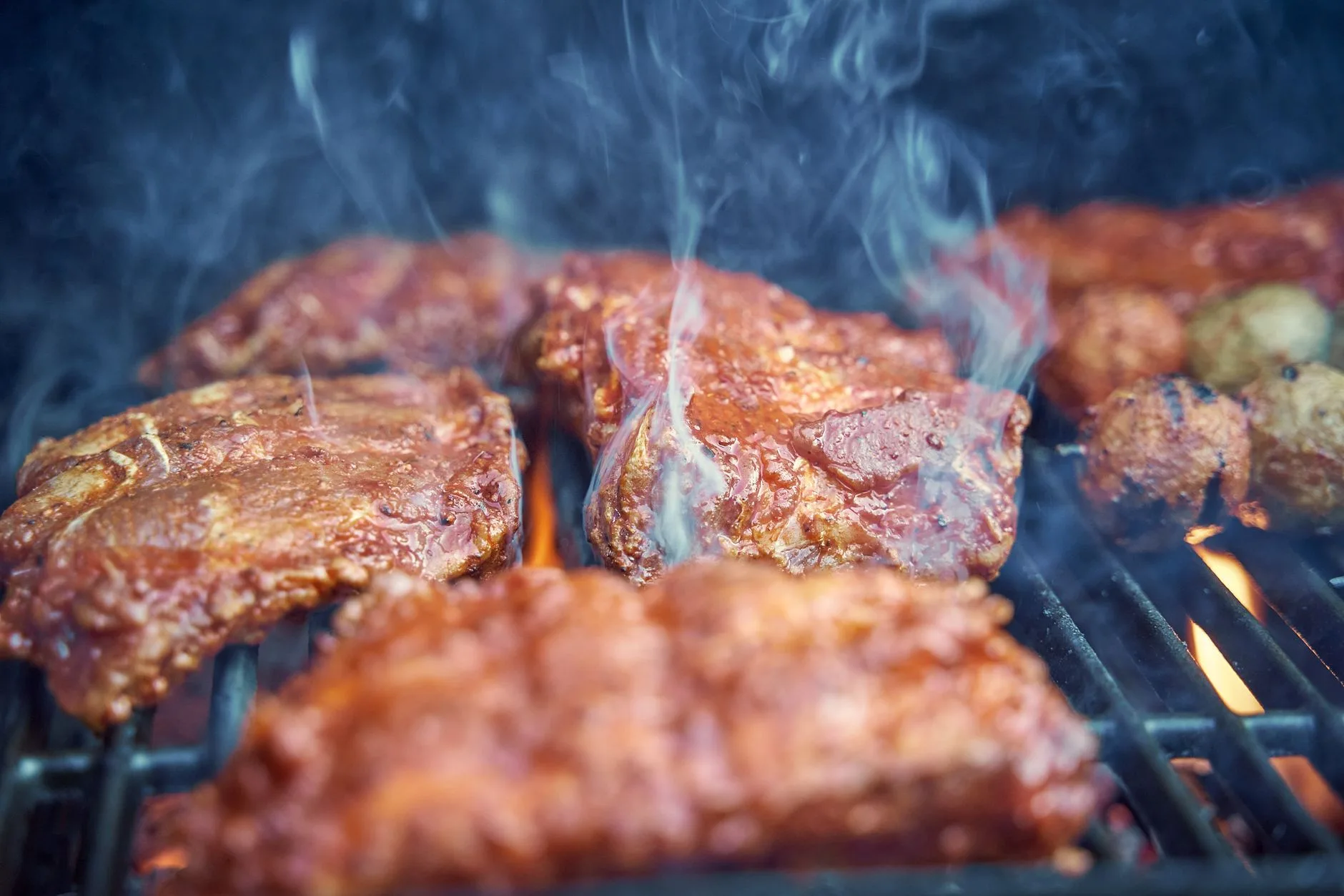 Charcoal grill smoking food over glowing coals