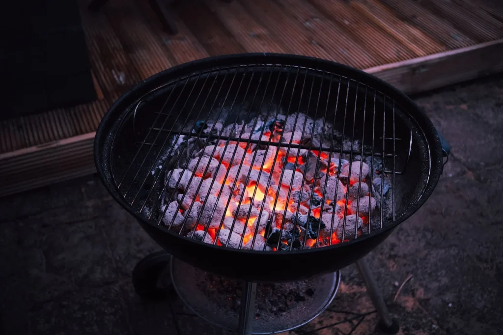 Charcoal kettle and kamado barbecue comparison on a patio