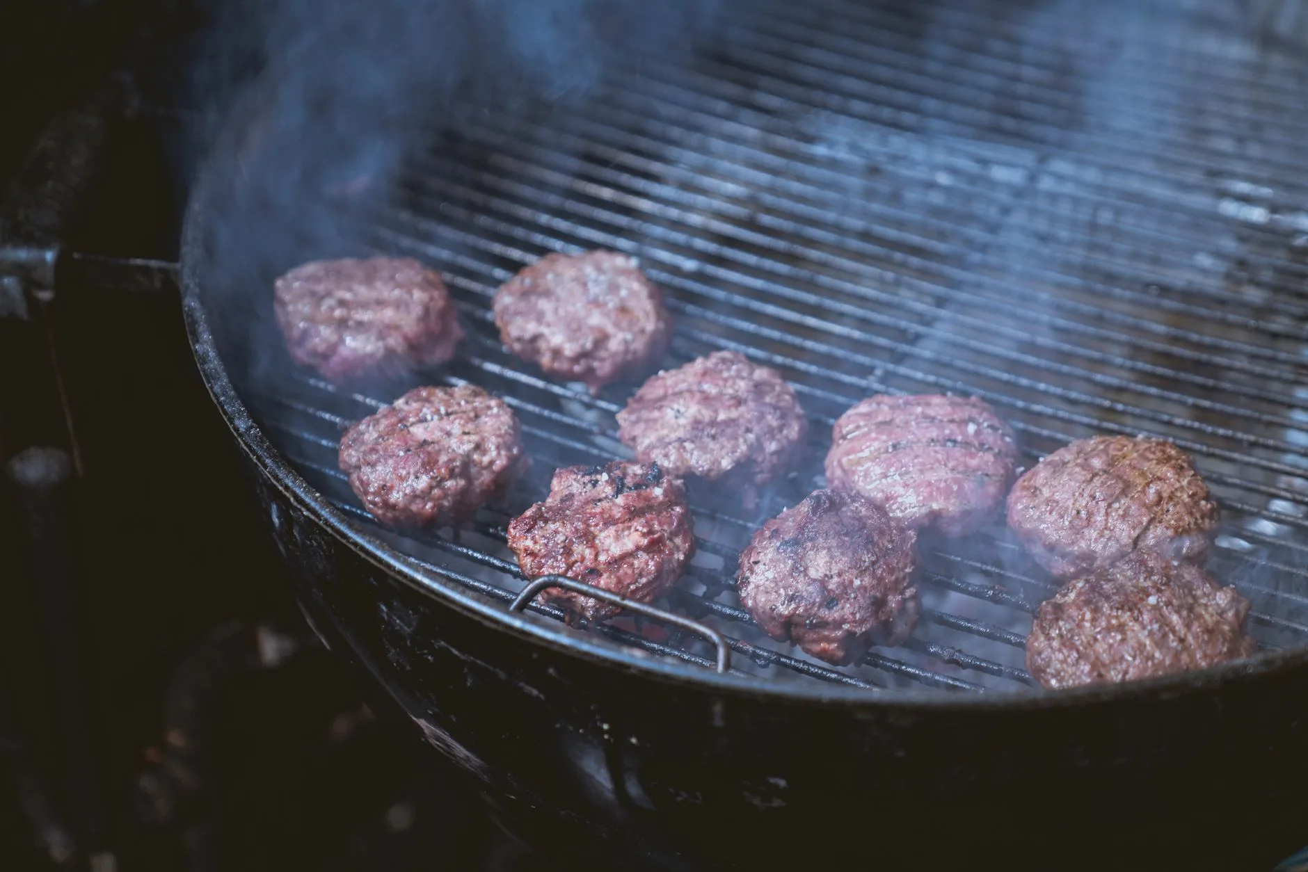 Black kamado charcoal grill set up for slow cooking on a patio