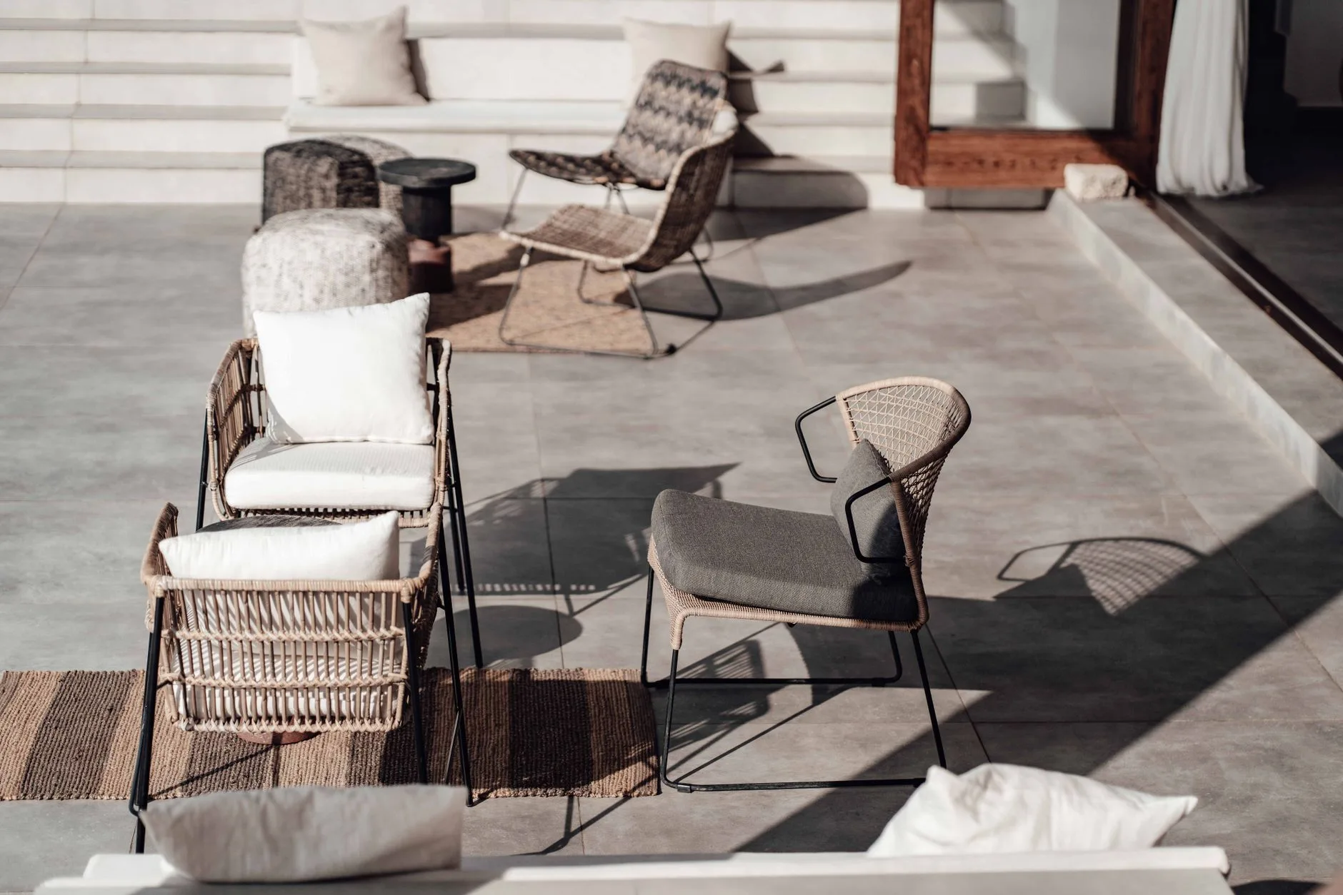 Outdoor rug placed under patio chairs in a garden seating area