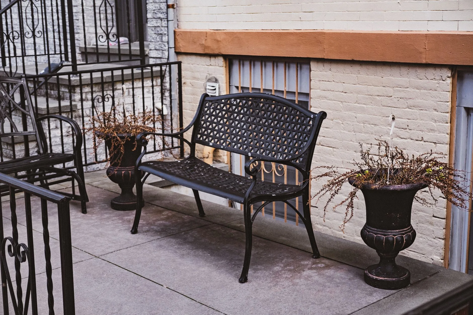 Small patio with compact furniture, planters and evening lights